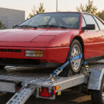 Voiture sportive ancienne correctement sanglée sur une remorque plateau